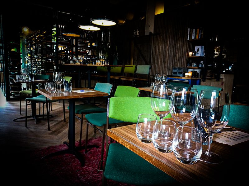 Tafels gedekt met proefglazen voor een besloten proeverij in de wijnwinkel van Aards